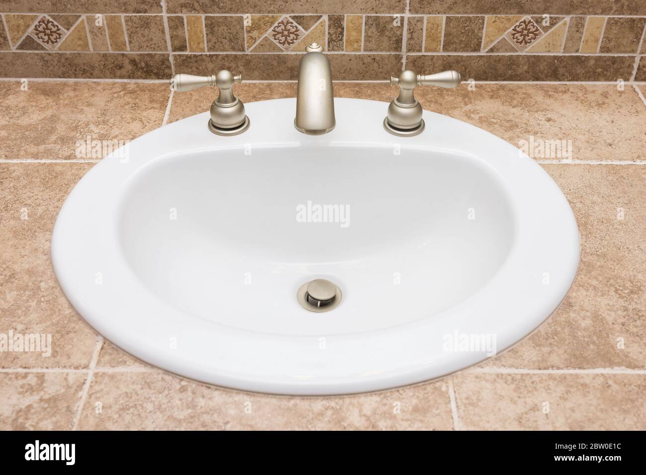 White porcelain drop in sink in tiled bathroom vanity Stock Photo Alamy