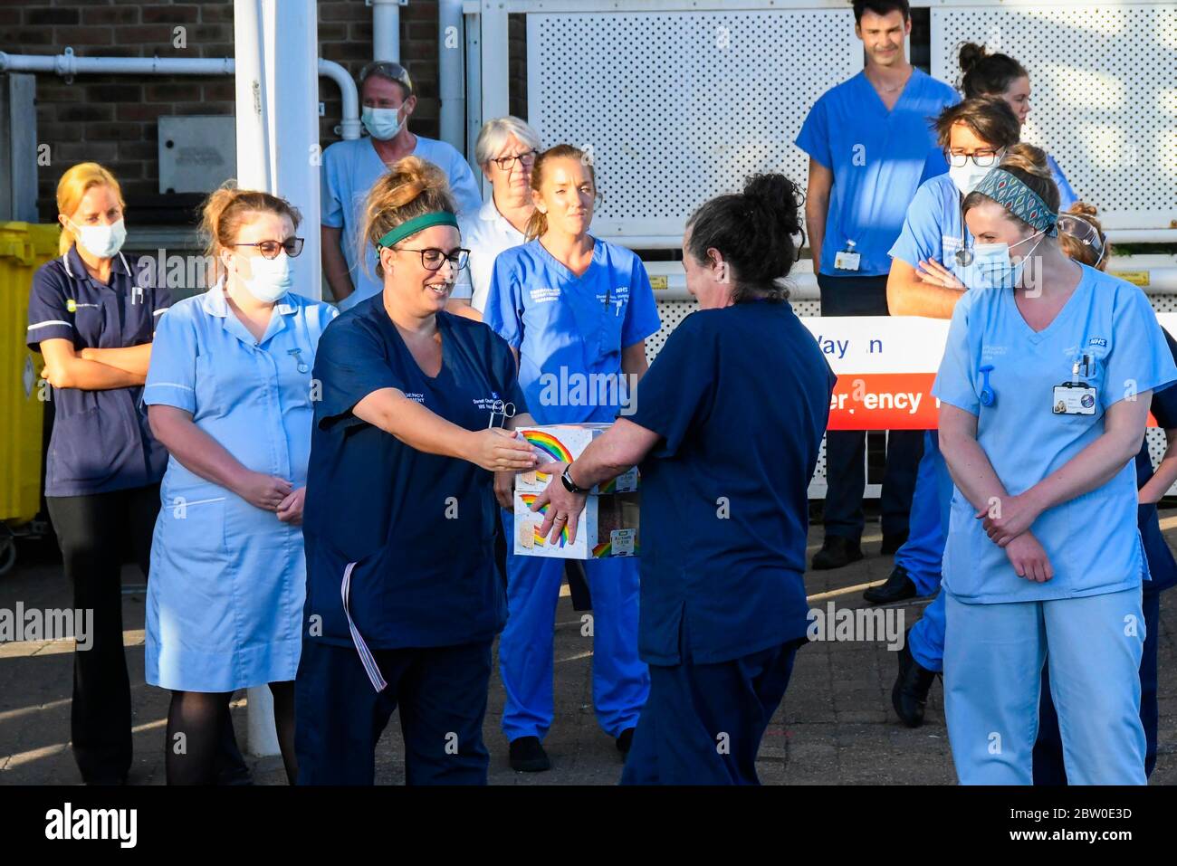 Dorset County Hospital, Dorchester, Dorset, UK.  28th May 2020.  Doctors, Nurses and frontline staff outside the Accident and Emergency entrance at Dorset County Hospital at Dorchester in Dorset to clap for the final time for the NHS, Carers, Key Workers and Front Line staff.  Ahead of the clap a member of the public gave the NHS staff cake.  Picture Credit: Graham Hunt/Alamy Live News Stock Photo