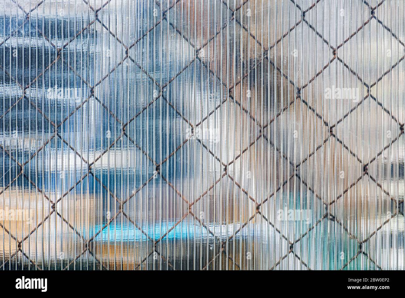 Iron mesh that shines through the surface of a plastic sheet to be used as a texture for the background. Stock Photo