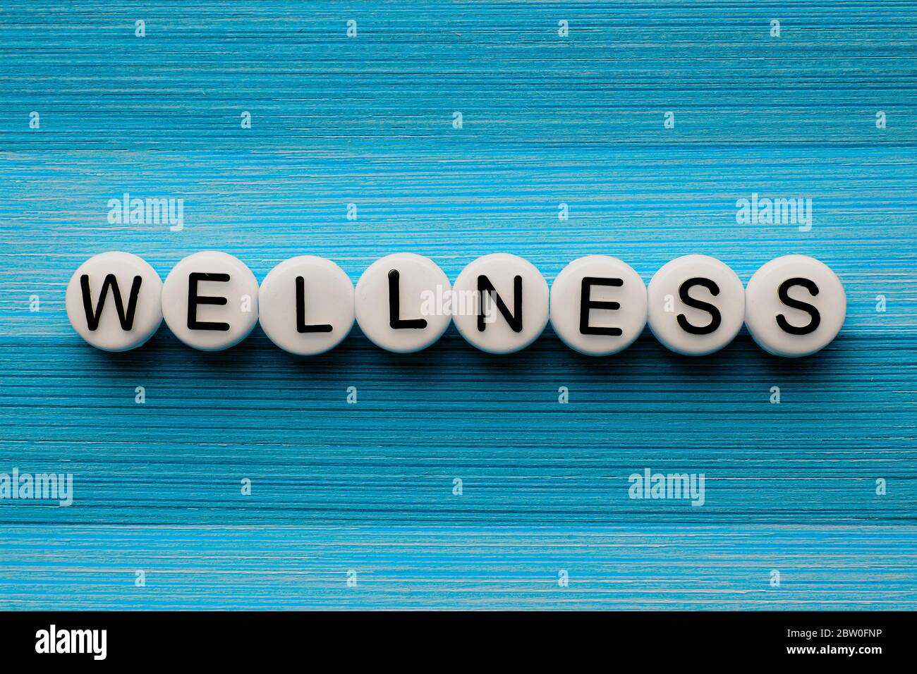 Wellness text on a blue wooden table Stock Photo
