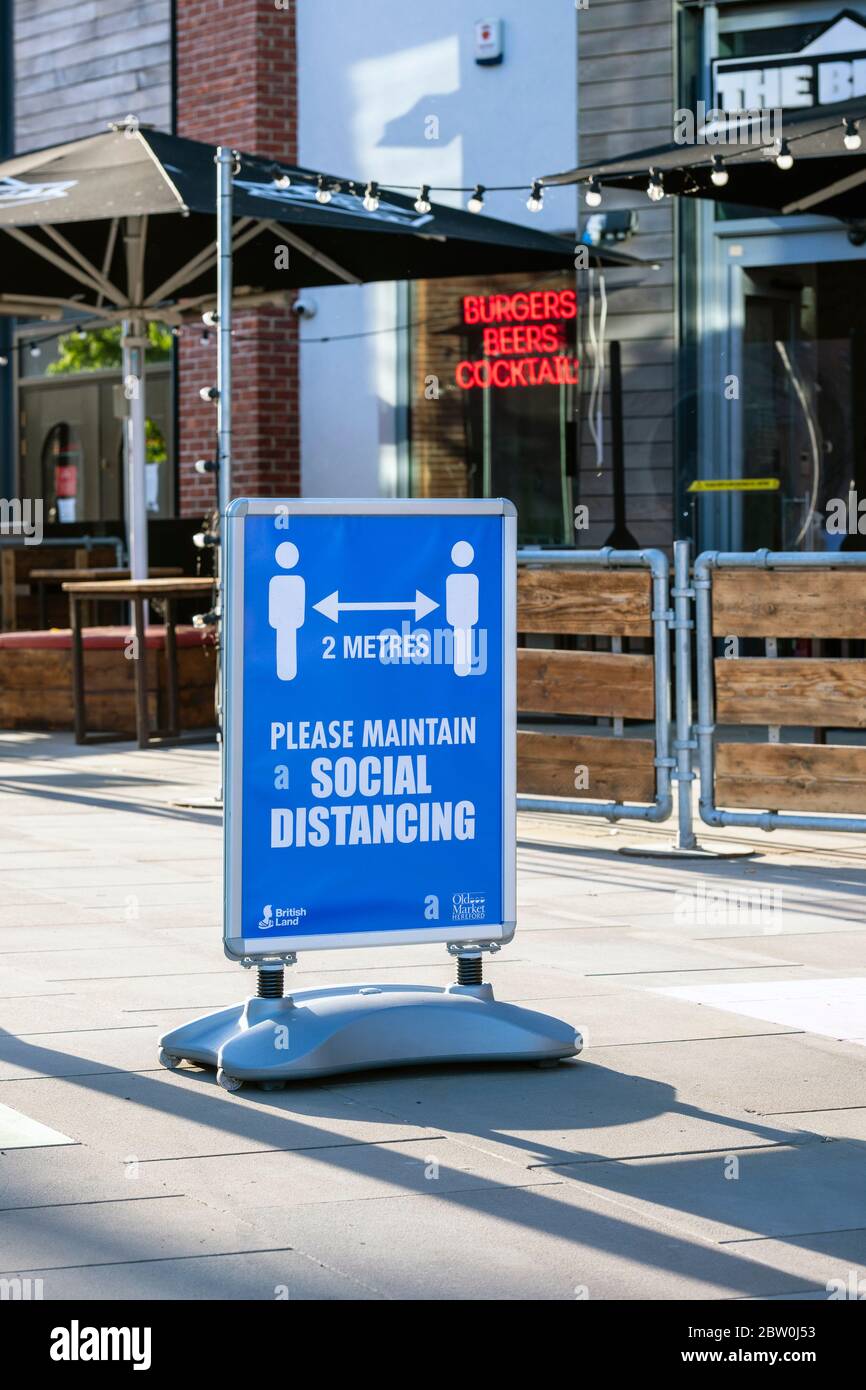 Social distancing sign in a UK shopping precinct. Stock Photo