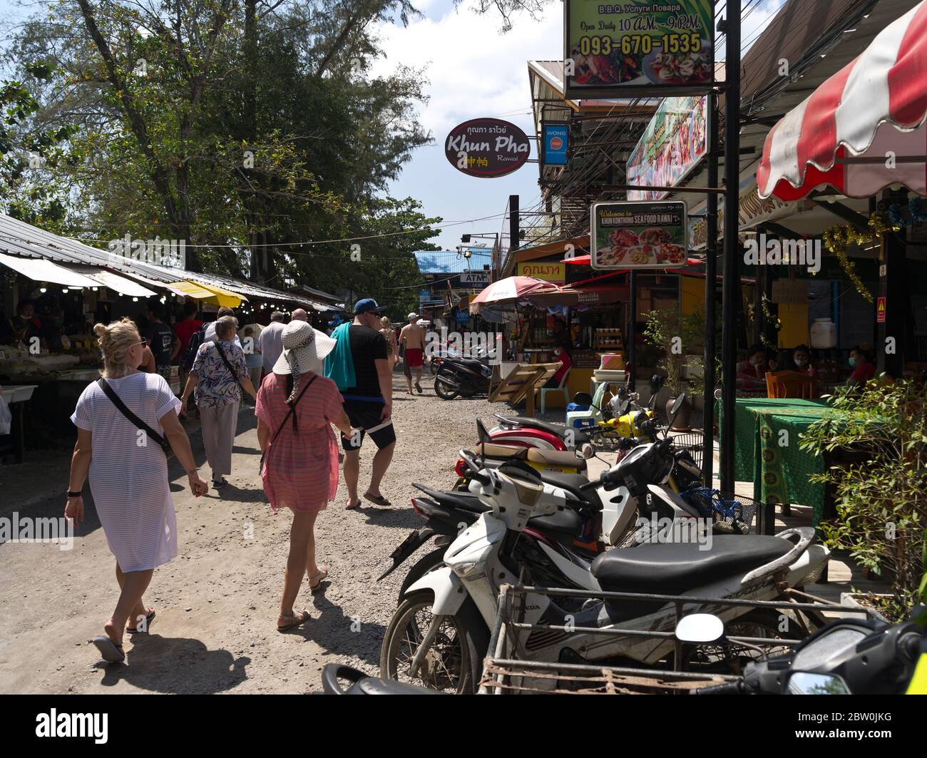 dh Rawai Restaurants street PHUKET THAILAND Tourists walking fish market motorbikes outside restaurant cafe holiday people Stock Photo