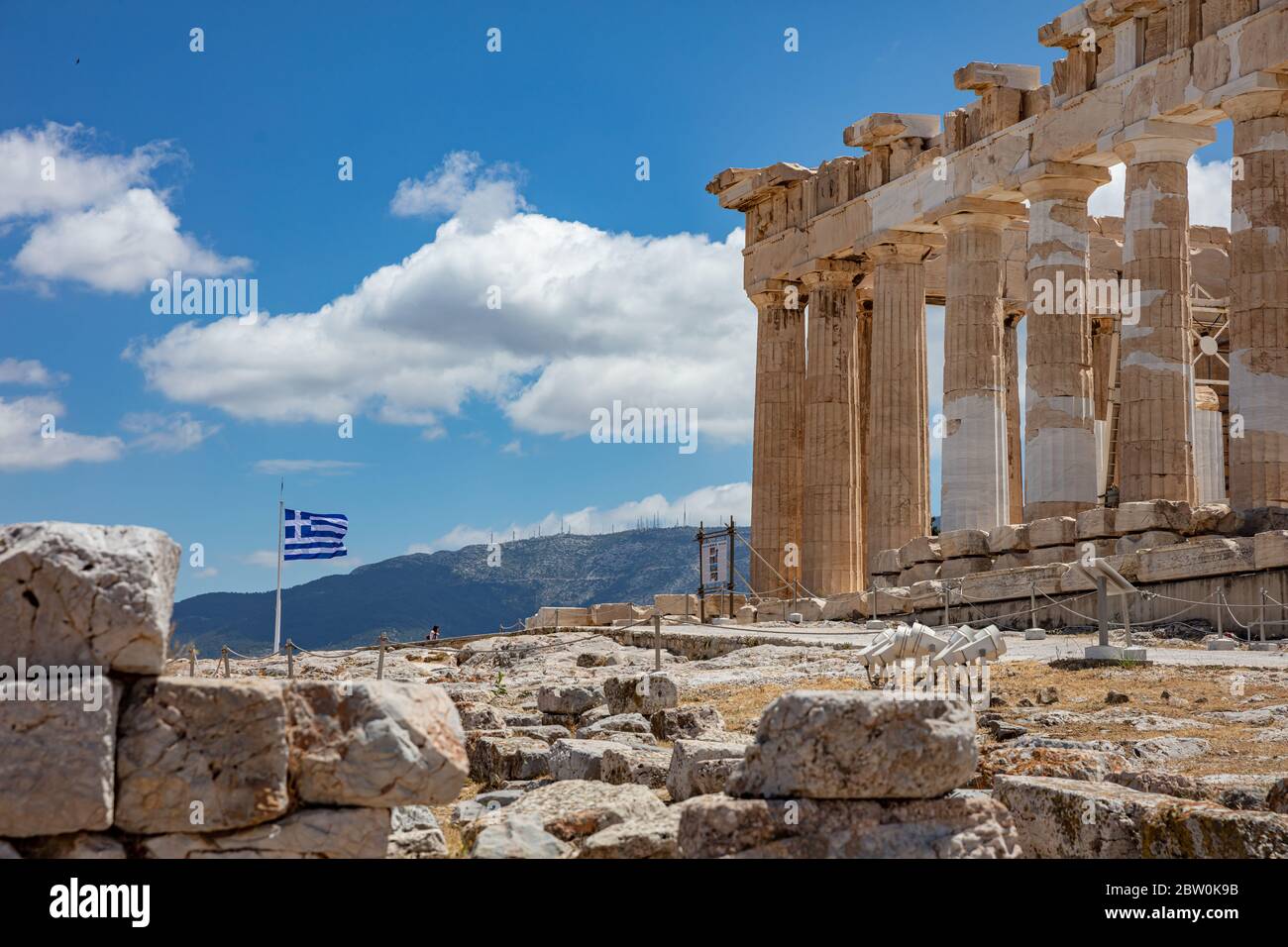 Athens Acropolis, Greece. Parthenon temple and greek flag waving against blue sky background, spring sunny day. Stock Photo