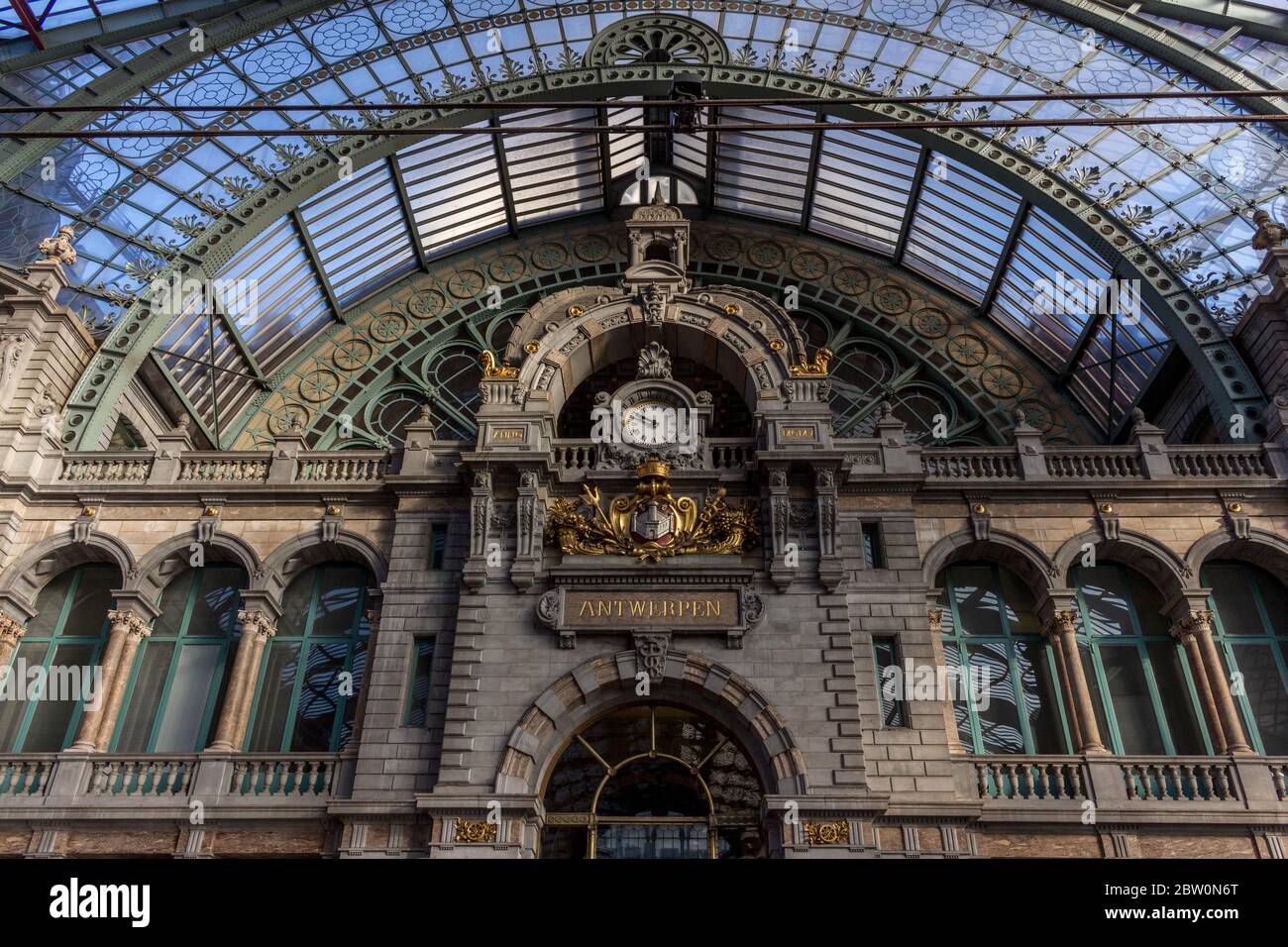 Magnificent Antwerp Train Station Clock in Morning light. Eclectic historic architecture. Time maker. in central perspective. Unique Stone Building in Stock Photo