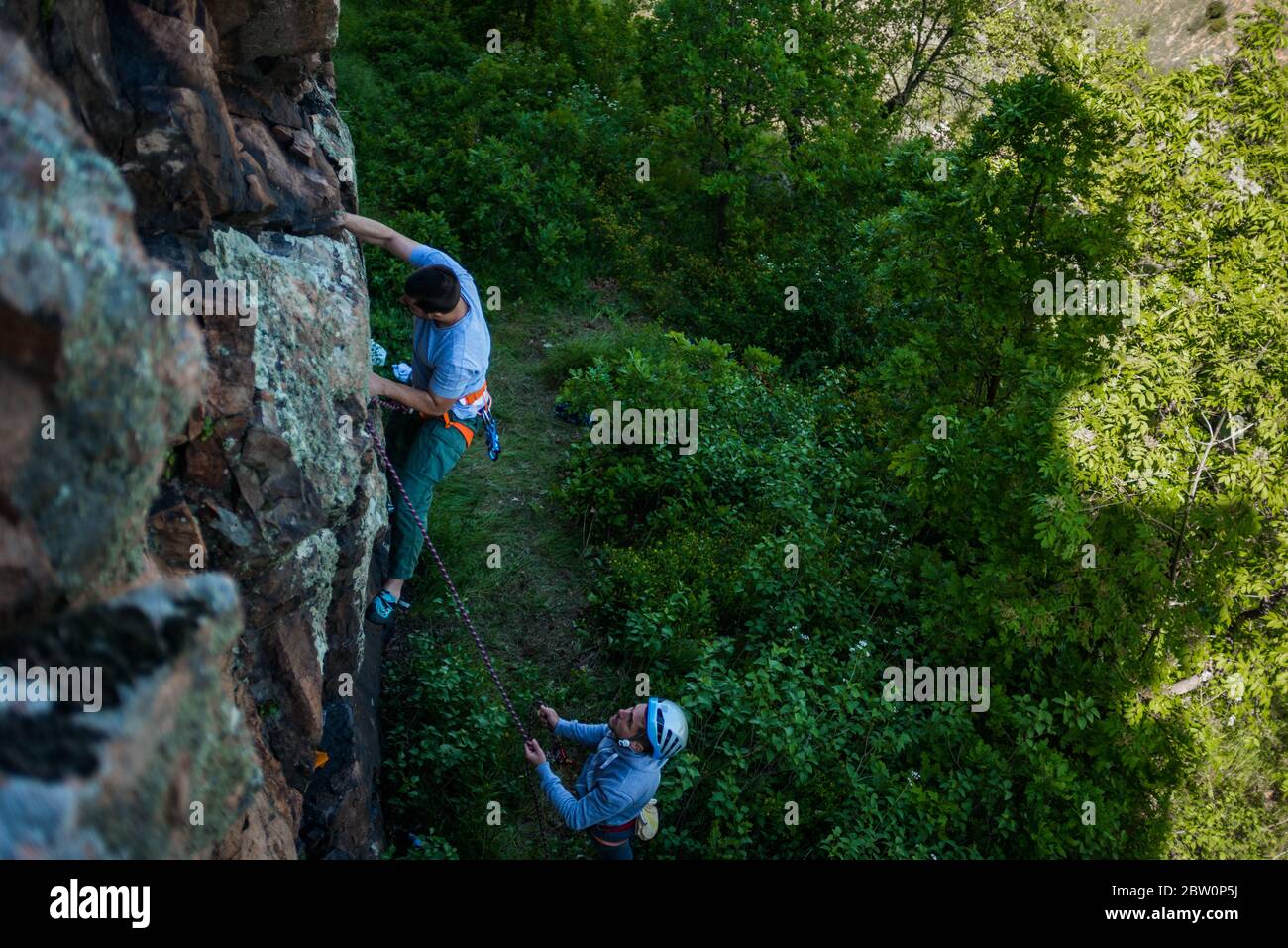 Two men about to go rock climbing and attaching the climbing rope to