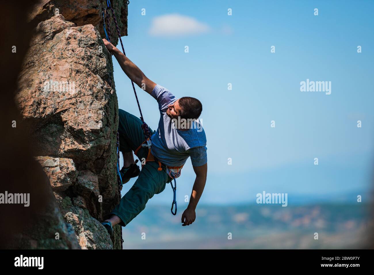 A man goes in for sports. Active lifestyle. Athlete on a rock Stock ...