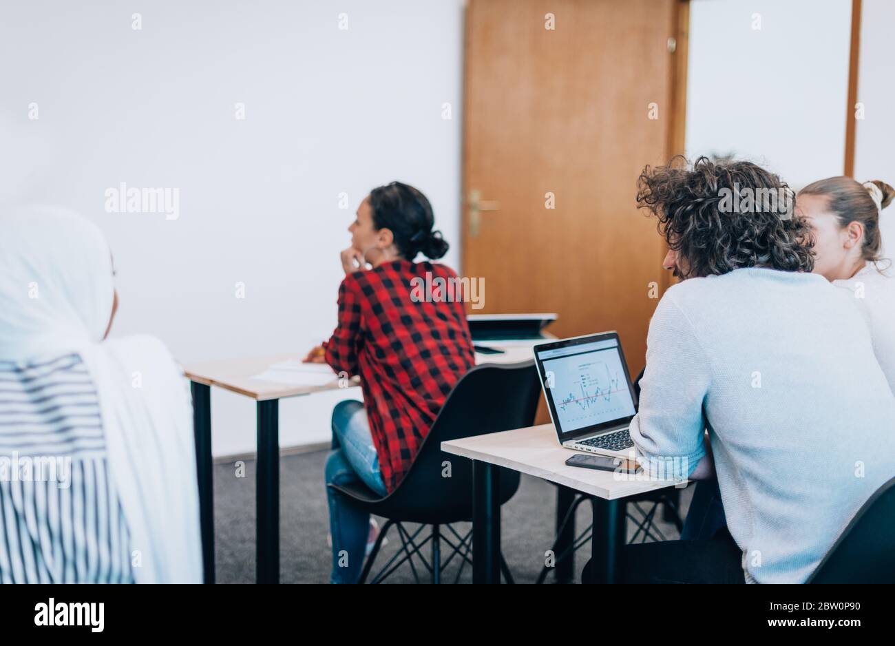 Young diverse team of people using laptops in a training session Stock Photo