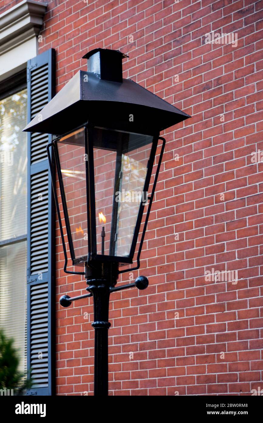 City Street lantern in front of a red brick wall Stock Photo