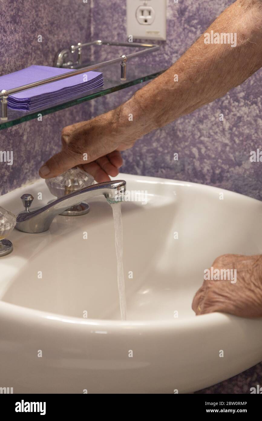 Bathroom sink turning on water Stock Photo Alamy