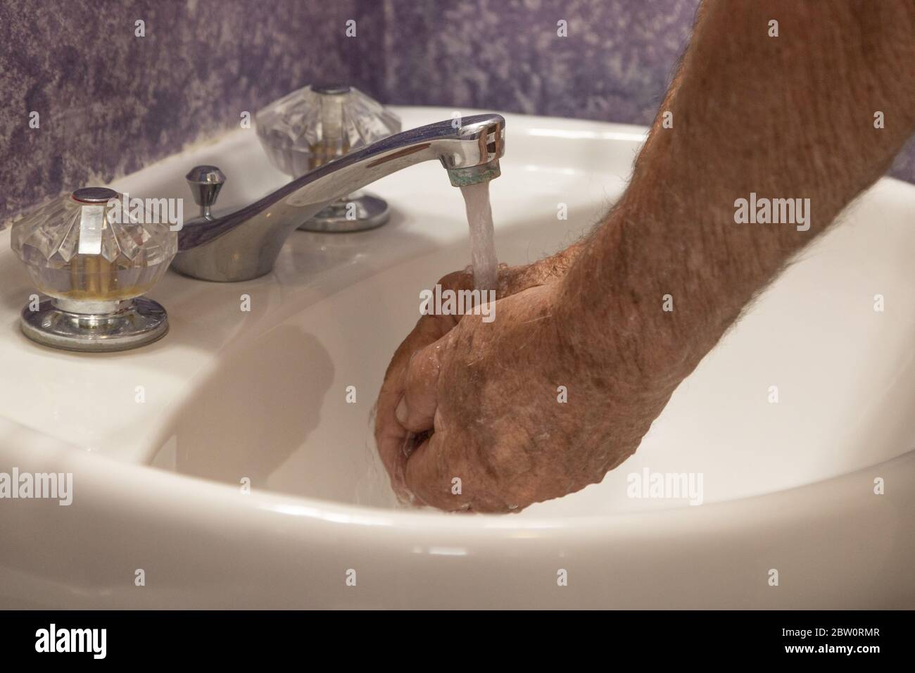 Bathroom sink cupping hands under running water Stock Photo Alamy