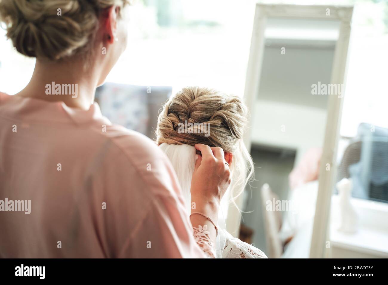 Rear view of hairstylist making bridal hairstyle. Hairdresser attaching veil to bride hair. Wedding day concept Stock Photo Alamy