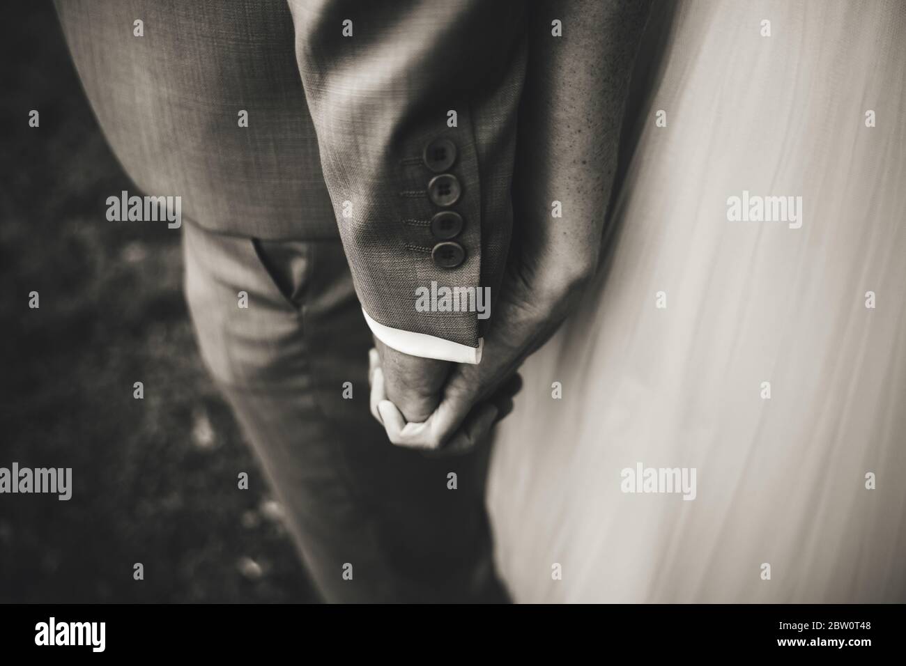 Black and white photo of wedding couple. Closeup view of hands holding ...