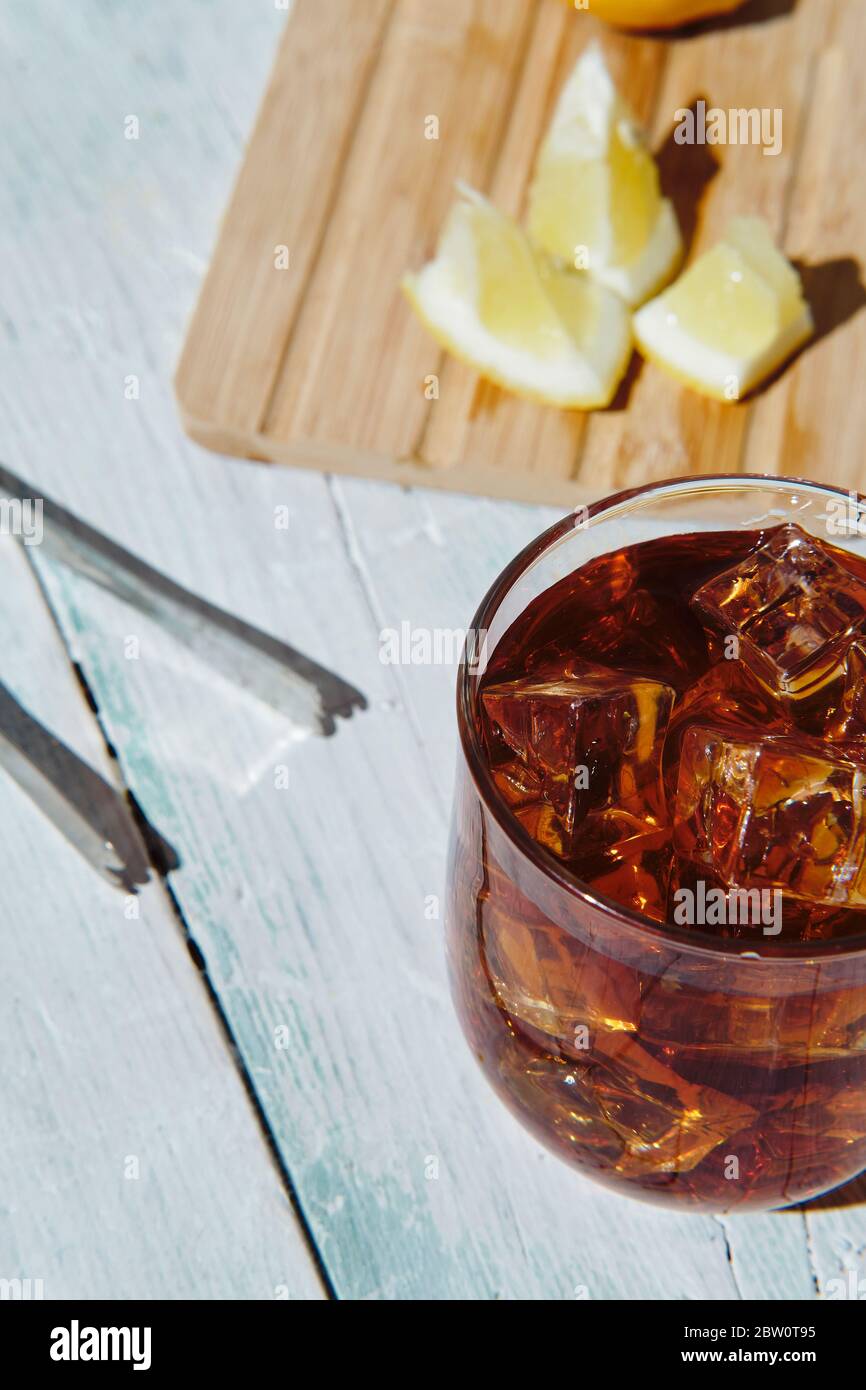 cola in a glass with ice and lemon on a white wooden base Stock Photo ...