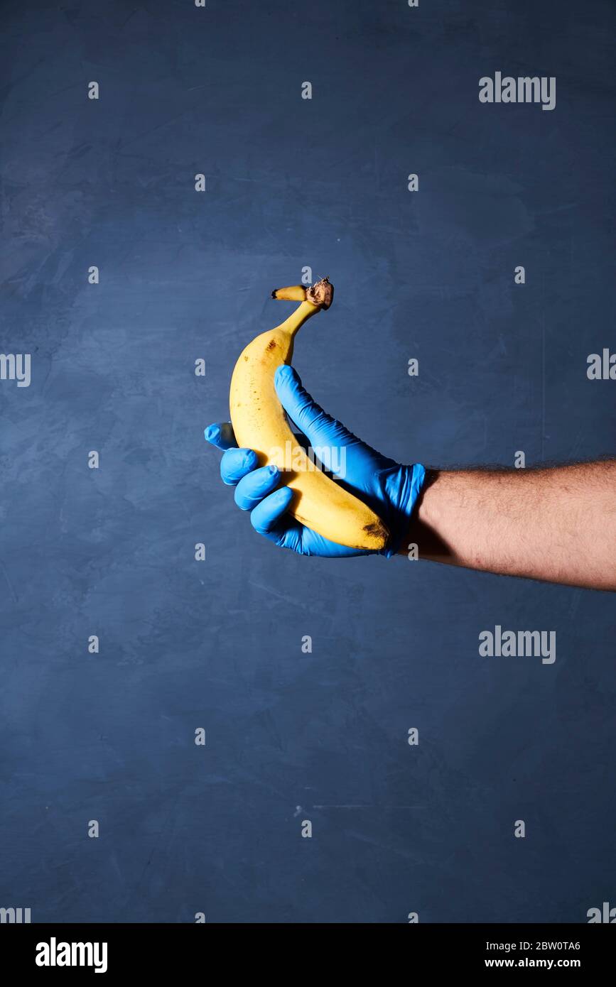 Banana fruit held with gloved hand Stock Photo - Alamy