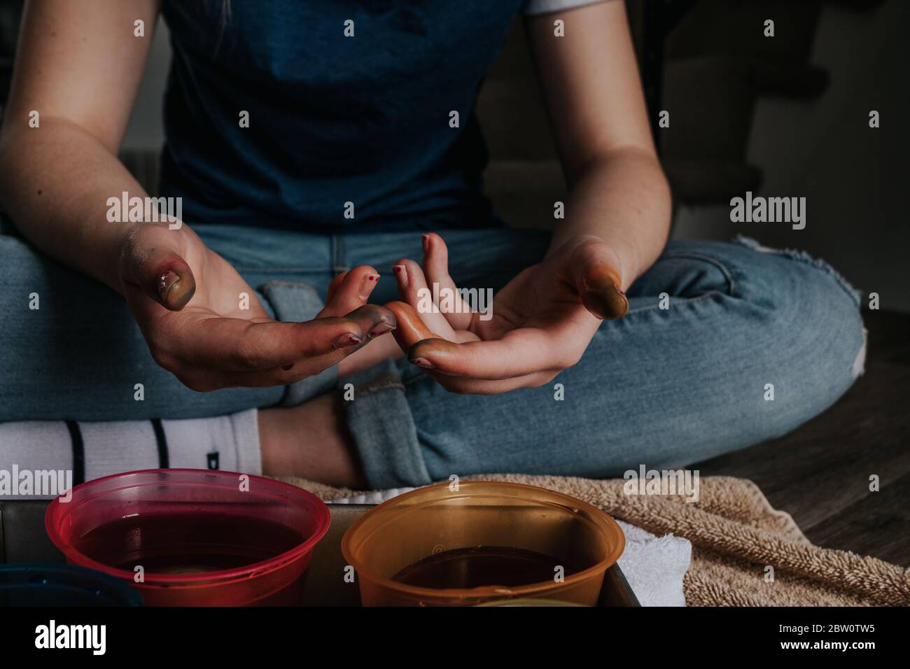 close up of preteen's hands while dying chicken eggs Stock Photo