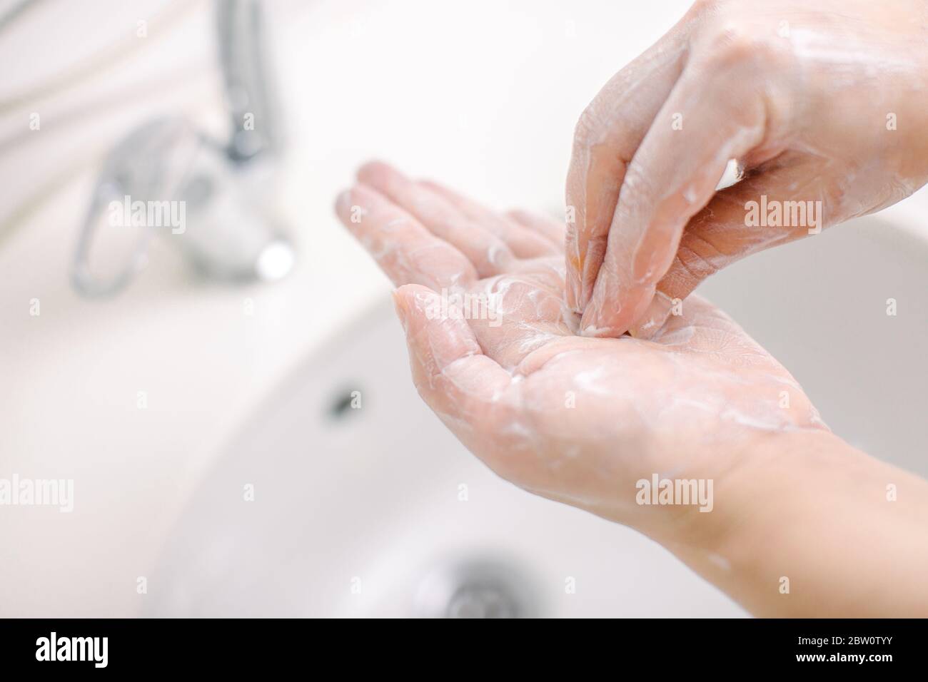 Woman washes her hands by surgical hand washing method. She washes his Stock Photo