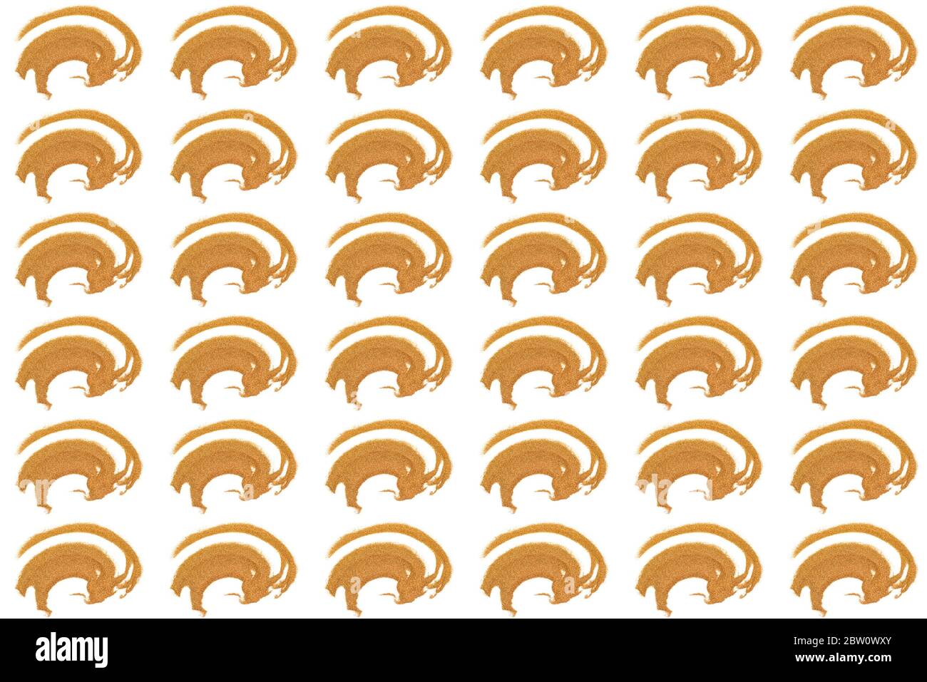 Pattern from abstract image of handful of golden coloured sand. Top view on isolated white background. Abstract golden ox. Symbol of Christmas. Stock Photo