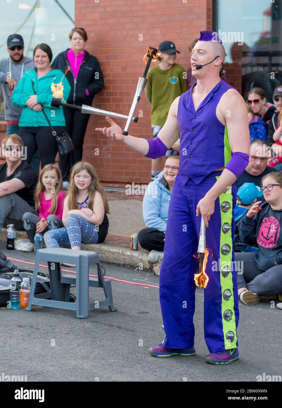 Saint John, New Brunswick, Canada - July 13, 2017: Annual Buskers Festival. A man with purple mohawk hair and dressed in purple juggles fire batons. Stock Photo