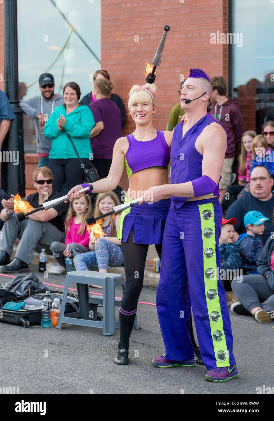 Saint John, New Brunswick, Canada - July 13, 2017: Annual Buskers Festival. A man and woman both dressed in purple juggle fire batons together. Stock Photo