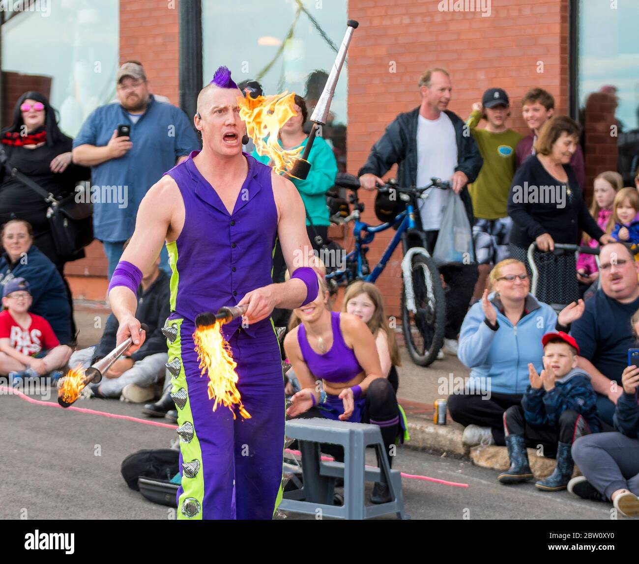 Saint John, New Brunswick, Canada - July 13, 2017: Annual Buskers On The Bay Festival. A man with purple mohawk hair juggles fire batons. Stock Photo