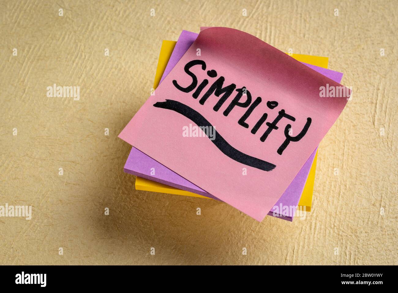 simplify reminder, pragmatic, declutter or get organized concept,  - black ink handwriting on a sticky note Stock Photo