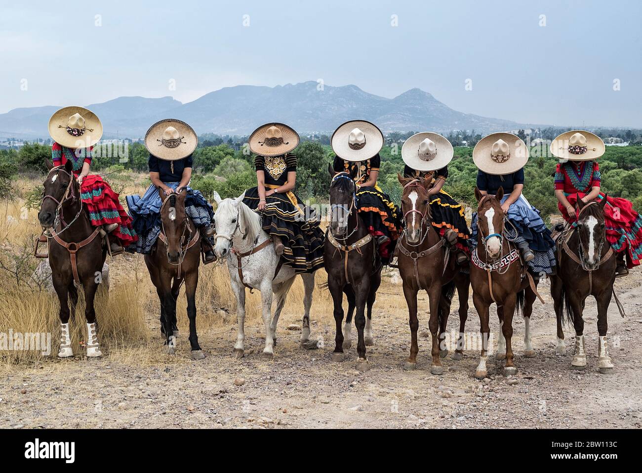 Mexican escaramuza ladies with traditional vest, riding horses Stock Photo