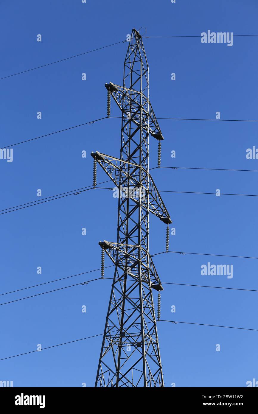 Electricity pylon against blue sky Stock Photo - Alamy