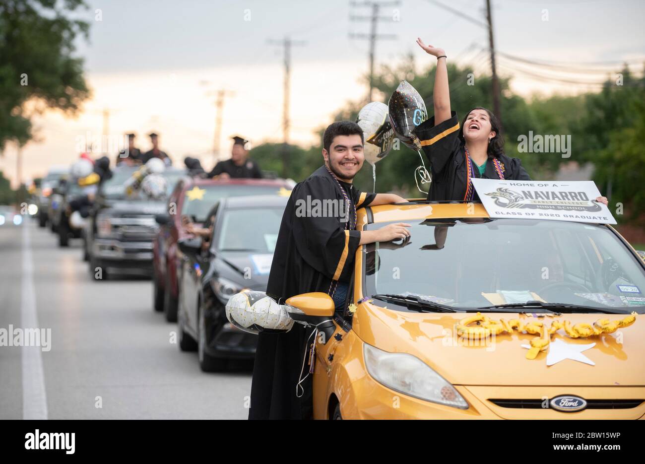 Graduates of Navarro Early College High School parade through their north Austin, Texas, neighborhood as they celebrate an academic finale shortened by the coronavirus pandemic. Stock Photo