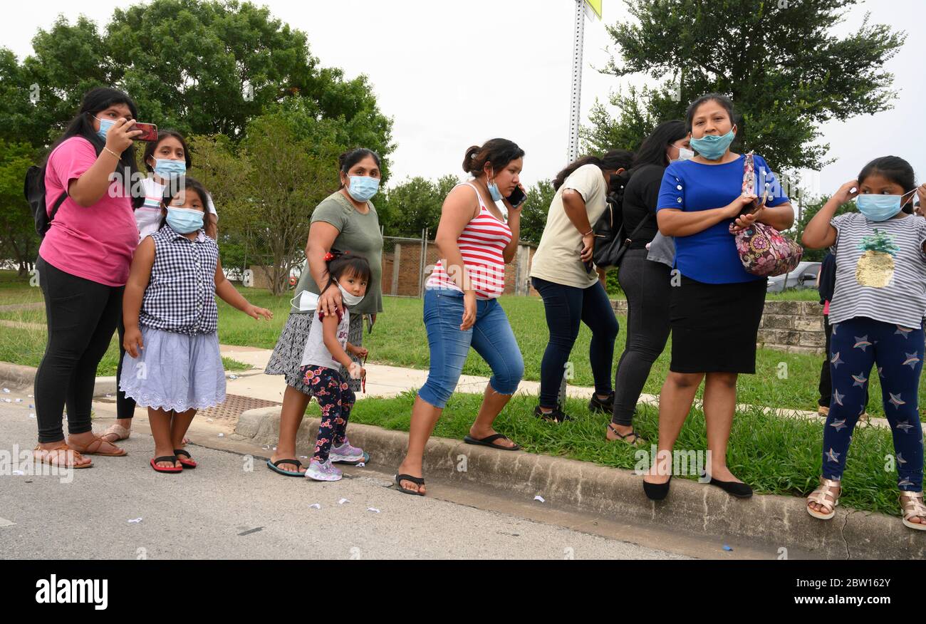 Family members and neighbors watch graduates of Navarro Early College High School parade through their north Austin, Texas, neighborhood, celebrating an academic finale shortened by the coronavirus pandemic. Stock Photo