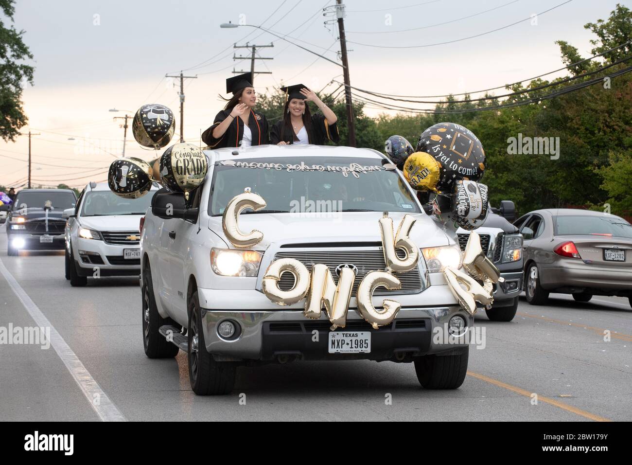 Austin, Texas, USA. 28th May, 2020. Texas graduates of Navarro Early College High School parade through their north Austin neighborhood on May 28, 2020 as they celebrate an academic finale shortened by the coronavirus pandemic. About 200 graduates piled into cars, waving at family and friends in the two-mile parade. Credit: Bob Daemmrich/ZUMA Wire/Alamy Live News Stock Photo