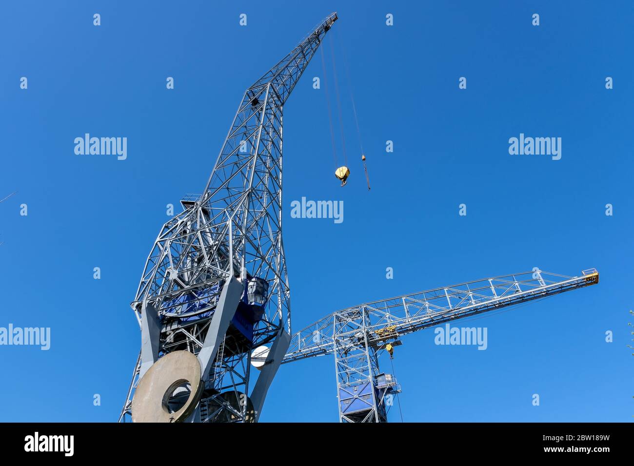 Huge cranes and ships anchored at harbor. International commercial port, city of Rotterdam background. Logistics business Stock Photo