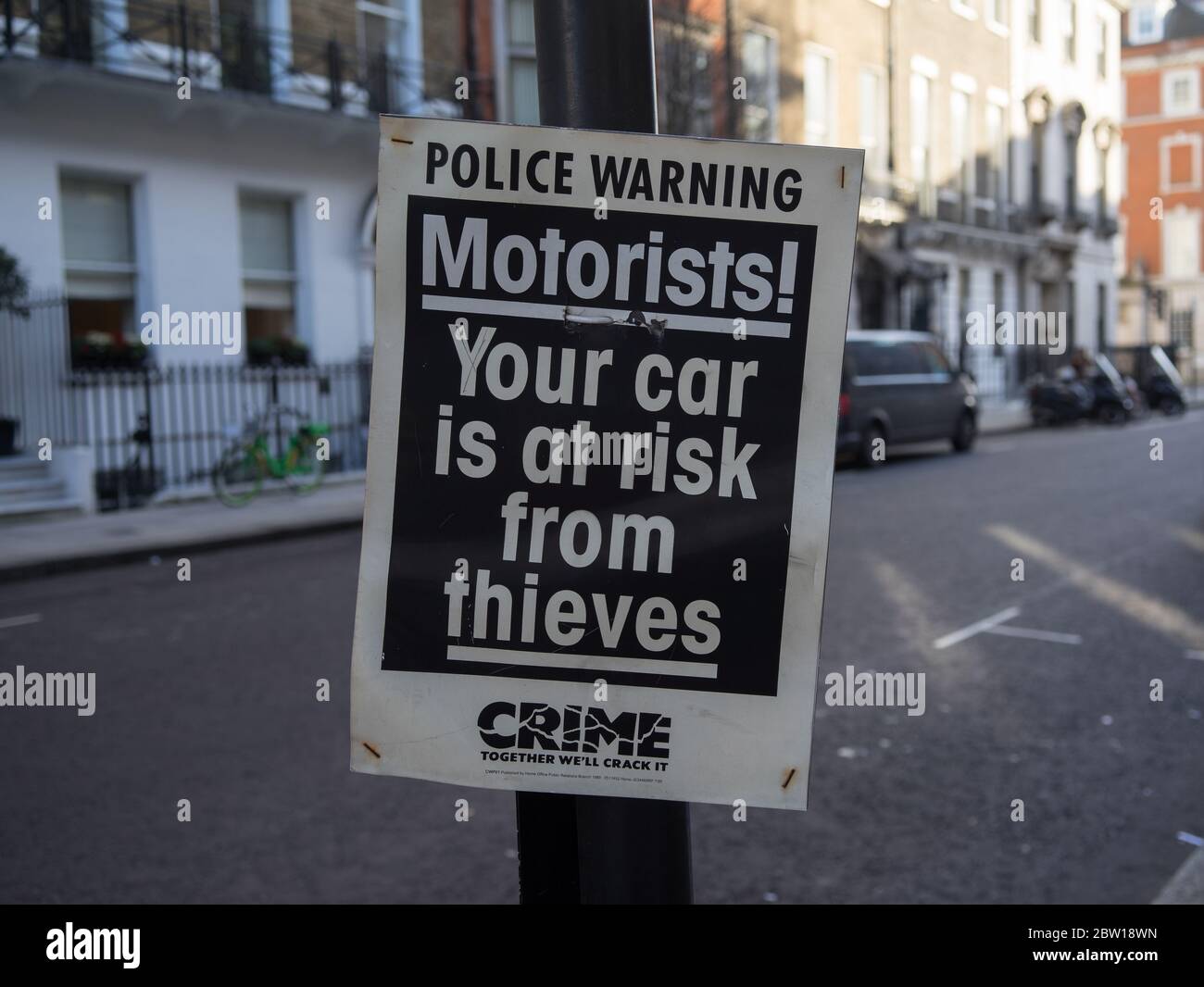 Police warning sign on a post that is warning motorists about car crime. London Stock Photo