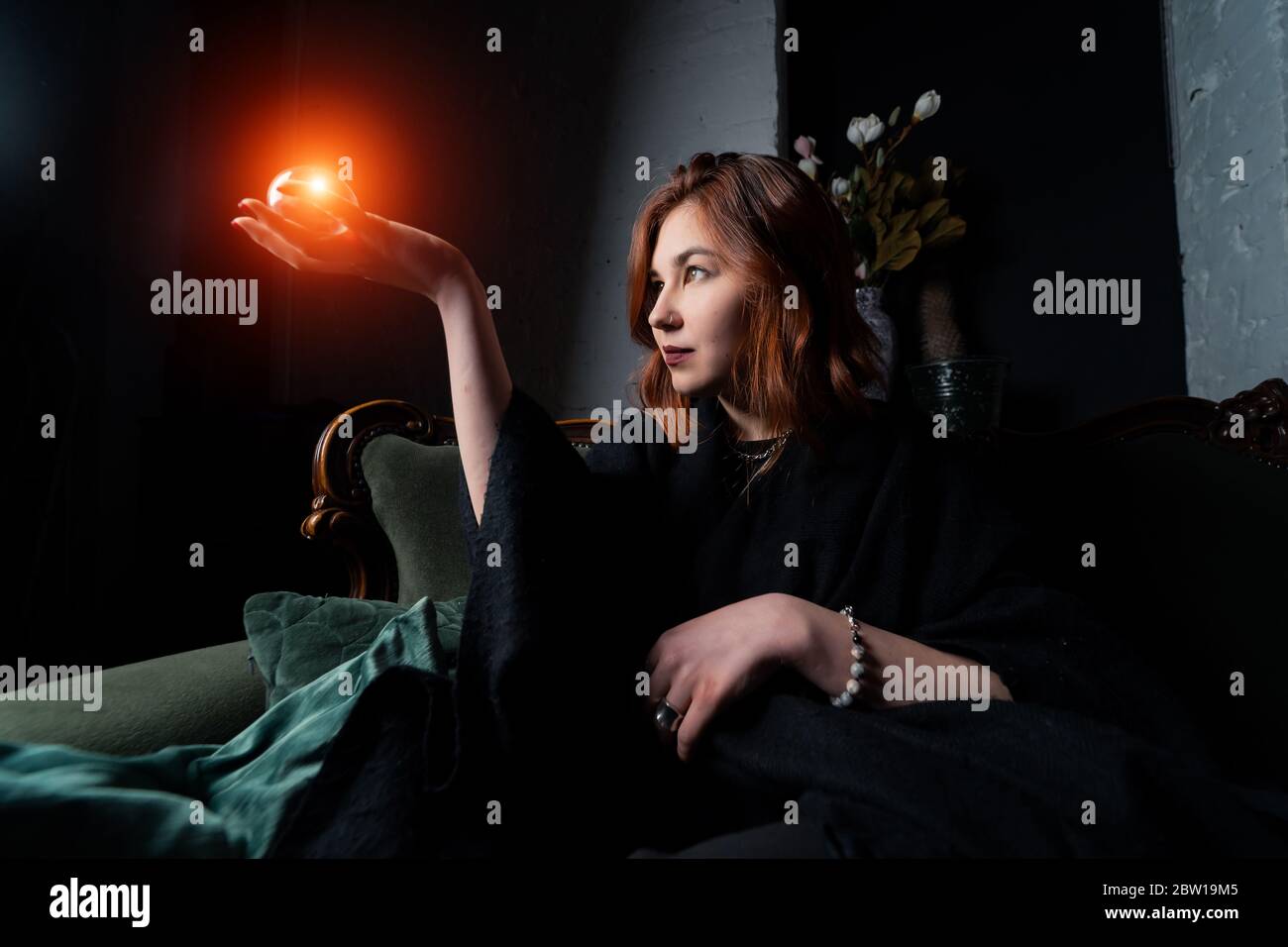 Woman in black suit holding crystal ball Stock Photo - Alamy