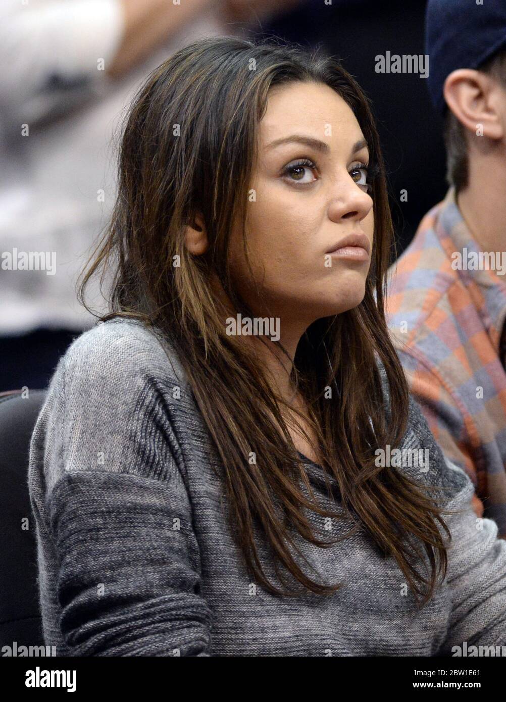 22 March 2014 Mila Kunis flaunts her engagement ring as she watches