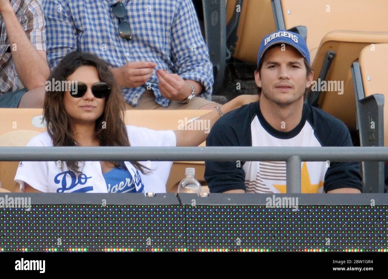 Mila Kunis and Ashton Kutcher watch Los Angeles Dogers v St Louis Cardinals in the MLB at Dodger Stadium, Los Angeles. April 2014 Stock Photo