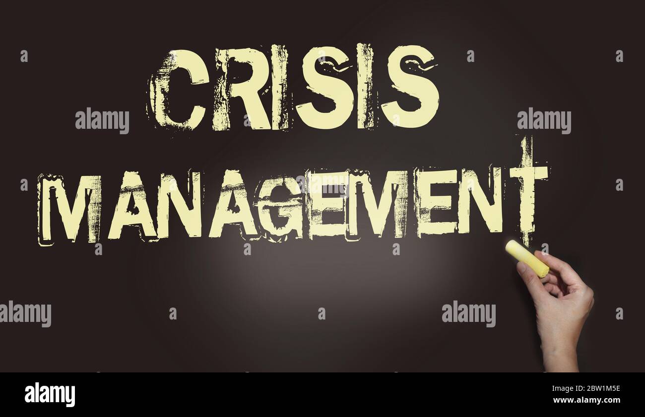 Crisis Management word on a black chalk Board, hand with chalk. Pale ...