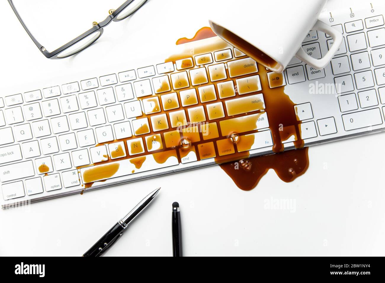 Cup of coffee spilled on office desk concept of careless clumsy or accident Stock Photo
