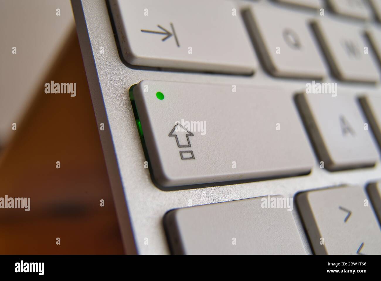 Shift key perspective closeup activated. Silver keyboard. Focus on key