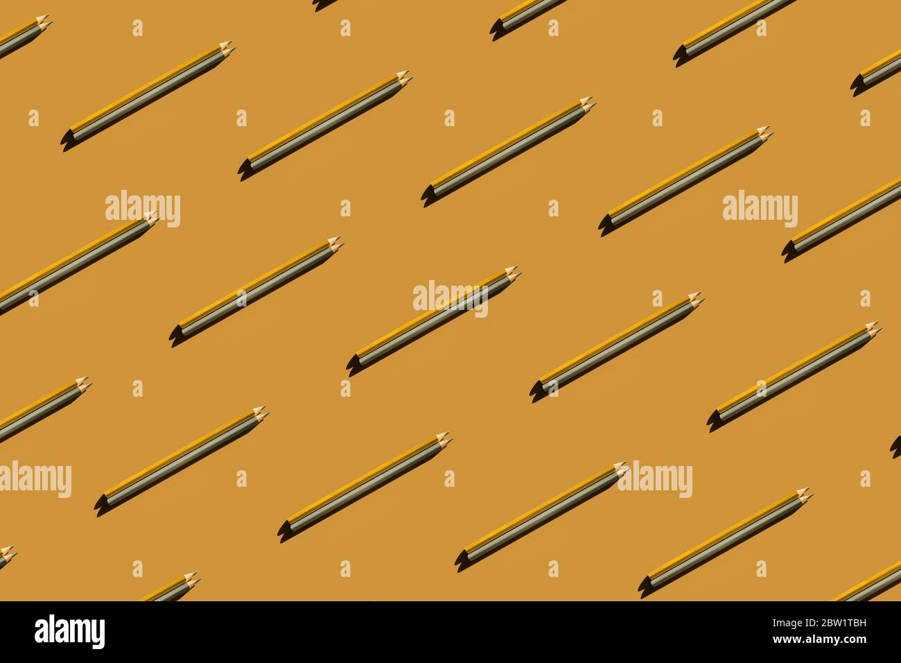 Pattern of trendy gold and silver pencils on gold background. Back to school, education and learning concept. Minimal modern concept. Stock Photo