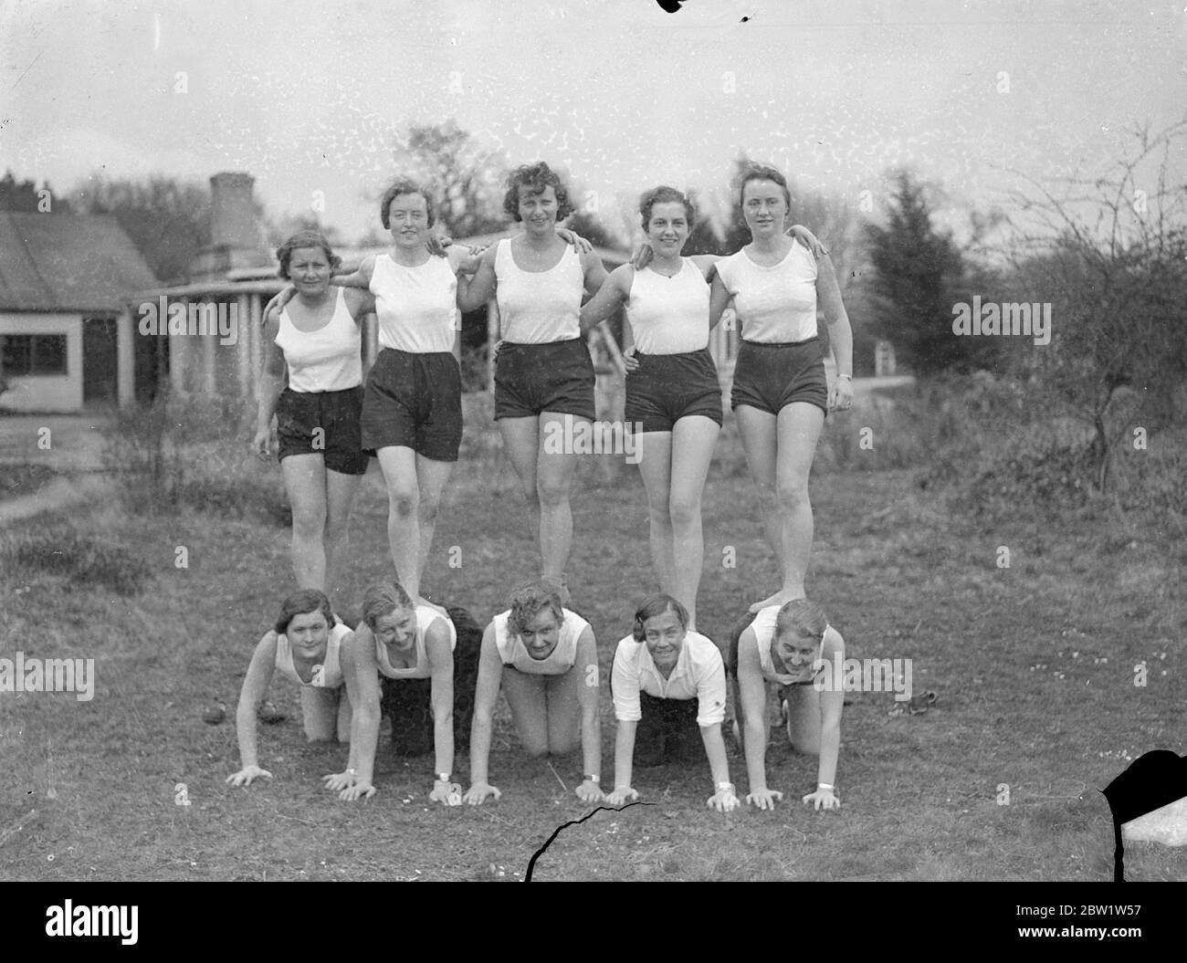 Fräuleins in the New Forest good will camp at Godshill. Girl members of the Hitler Youth Movement - students, clerks and factory hands between the ages of 18 and 25 - are attending a second annual camp organised to promote Anglo - German friendship at Godshill in the New Forest in Hampshire. They are to entertain a party of English girls over the weekend. Young girls from England are attending a similar camp in Germany. Photo shows: the German girls playing games, exercising at the New Forest camp. 10 April 1937 Stock Photo
