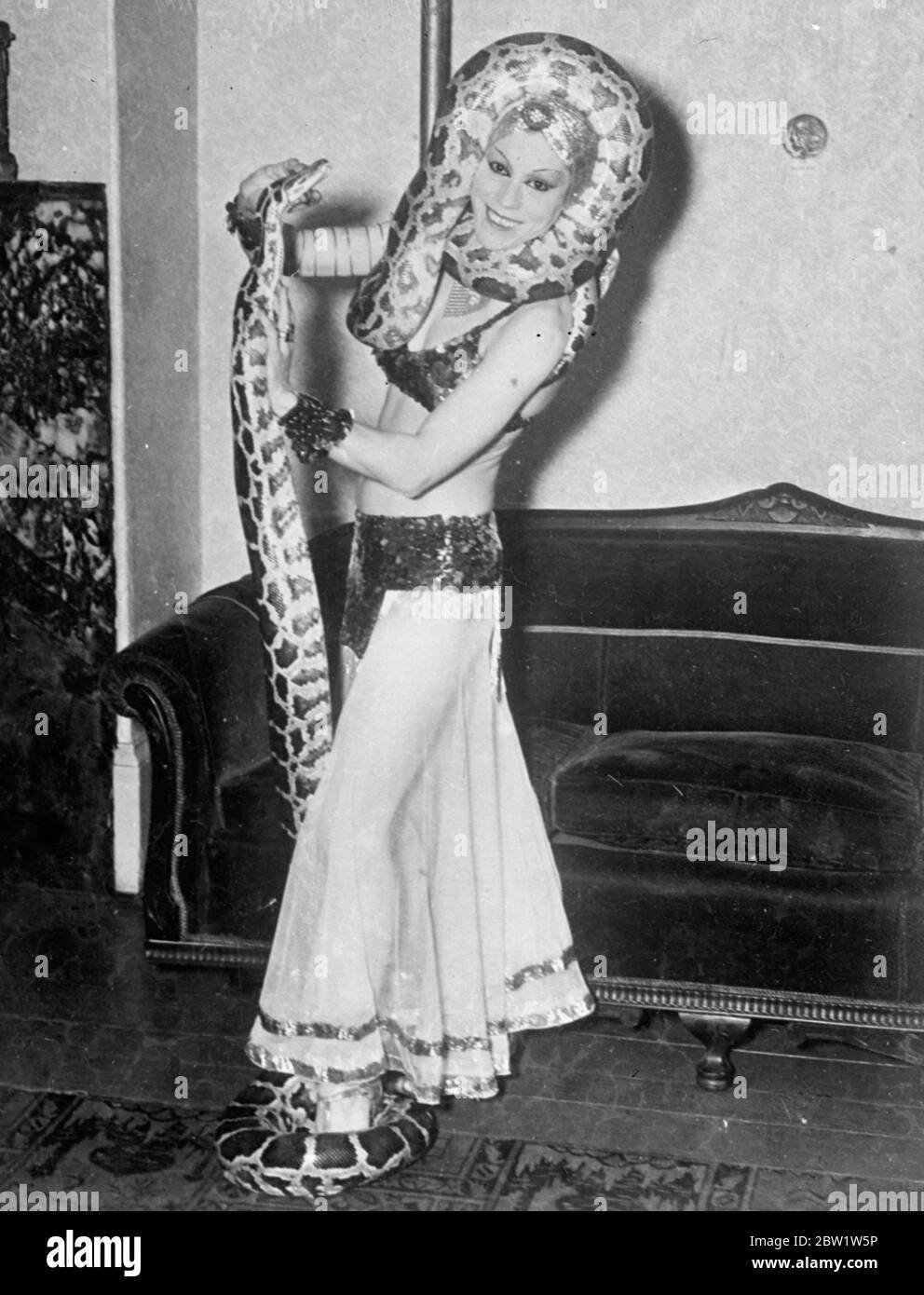 Aerial, a striptease actress from South America, has introduced a new thrill into her act, and performs in New York with two ten foot pythons. Photo shows: Aerial, the South American striptease actress, with her pythons. 1937 Stock Photo