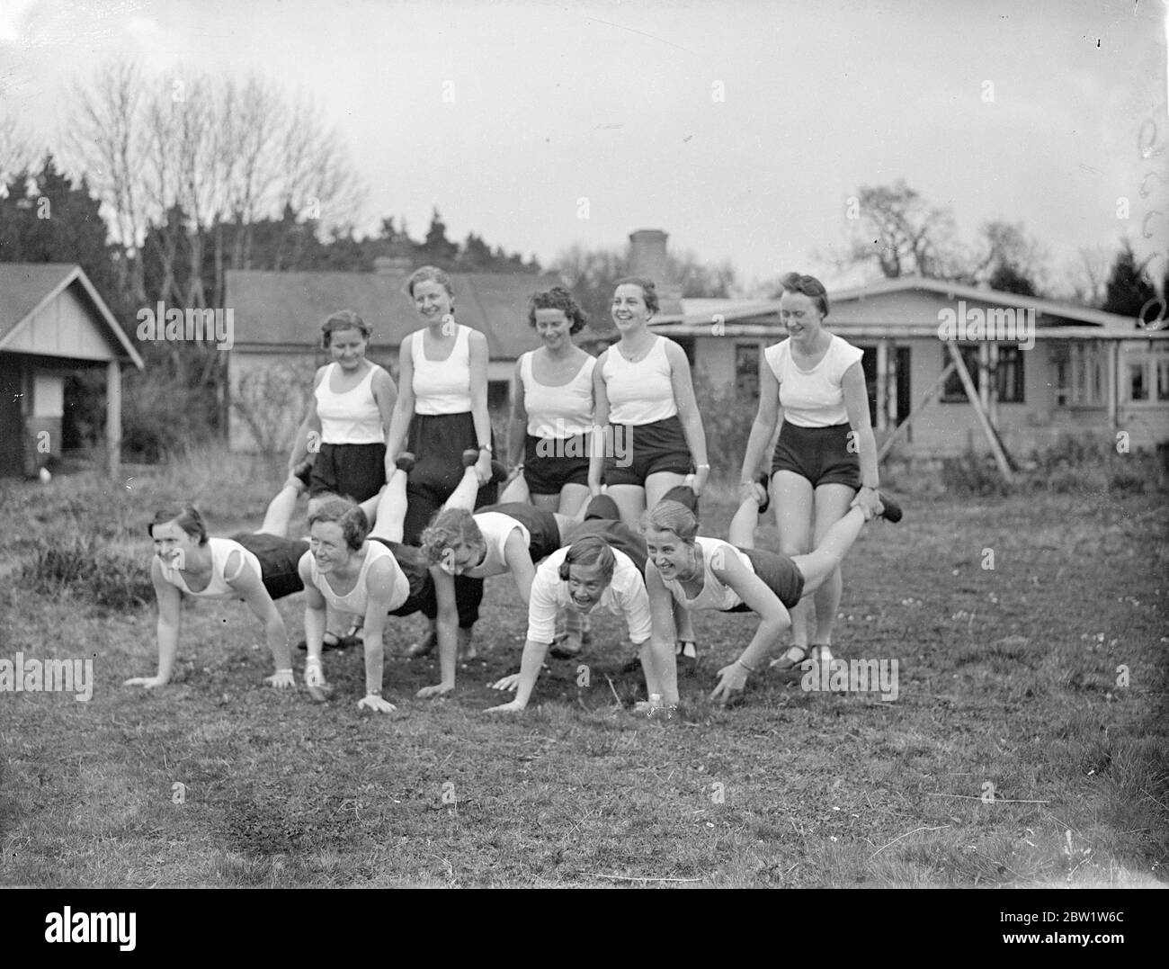 Fräuleins in the New Forest good will camp at Godshill. Girl members of the Hitler Youth Movement - students, clerks and factory hands between the ages of 18 and 25 - are attending a second annual camp organised to promote Anglo - German friendship at Godshill in the New Forest in Hampshire. They are to entertain a party of English girls over the weekend. Young girls from England are attending a similar camp in Germany. Photo shows: the German girls in a wheelbarrow race at the camp. This is one of the games encouraged to promote physical fitness. 10 April 1937 Stock Photo