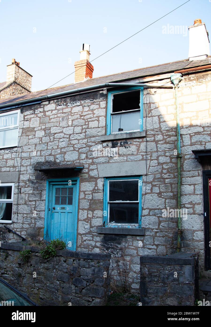 Unkempt / untidy exterior of an empty / disused stonebuilt terraced