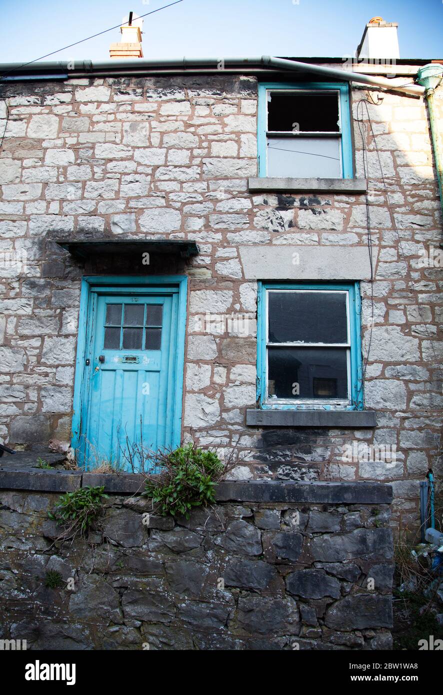 Unkempt / untidy exterior of an empty / disused stonebuilt terraced