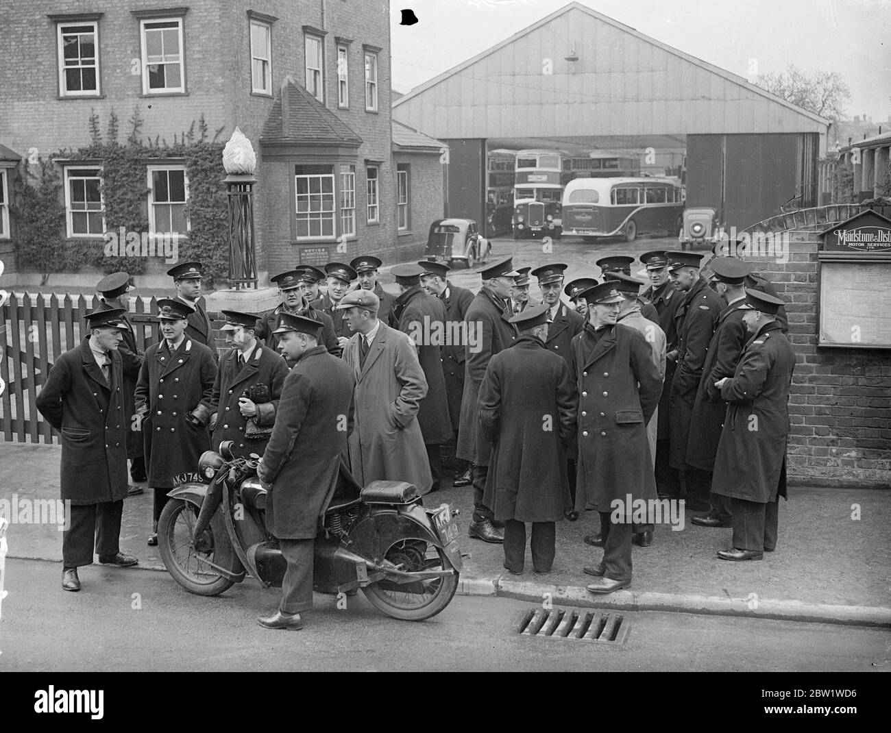 Maidstone strikers 'blockade' depot in attempt to prevent buses leave. There is still no sign of a settlement in the strike of Maidstone and District Bus Company employees, and the dispute is spreading. Strikers are 'blockading' the depot so that no buses can leave, though 'permission' to operate has been given to some private owners. Photo shows, strikers gathered outside the depot at Maidstone, where an attempt is being made to prevent buses leaving. 22 April 1937 Stock Photo