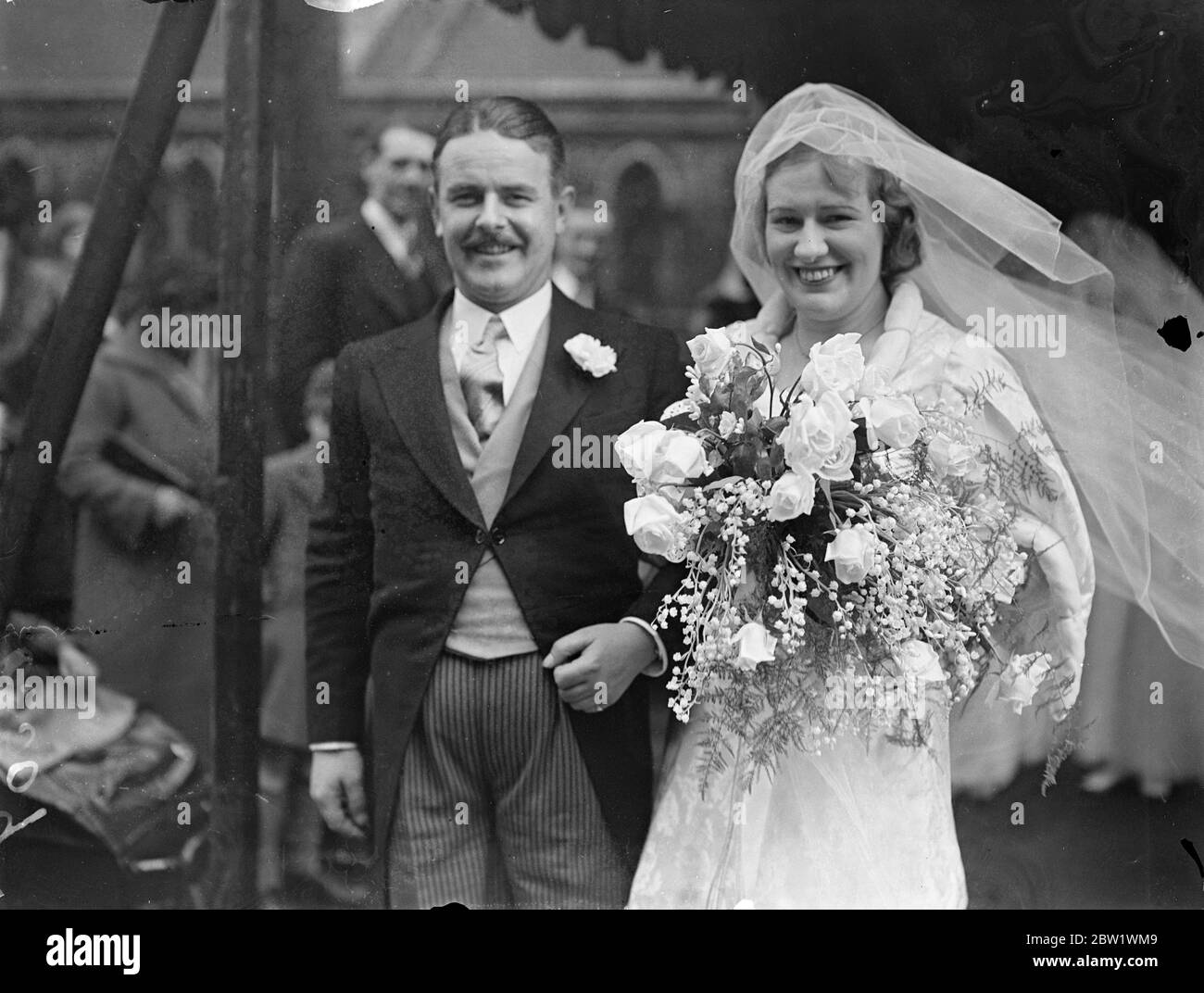 Radio actor weds actress in London. Bishop of London officiate. Mr Norman Shelley, the radio actor, and Miss Monica Brett, the actress, were married at St Stephen's Parish Church, Gloucester Road, Kensington. The Bishop of London, Dr Winnington Ingram officiated, and Lesley Woodgate, the BBC conductor, played the organ. Photo shows, the bridegroom lifting the bride's veil as they faced the photographer after the ceremony 16 April 1937 Stock Photo