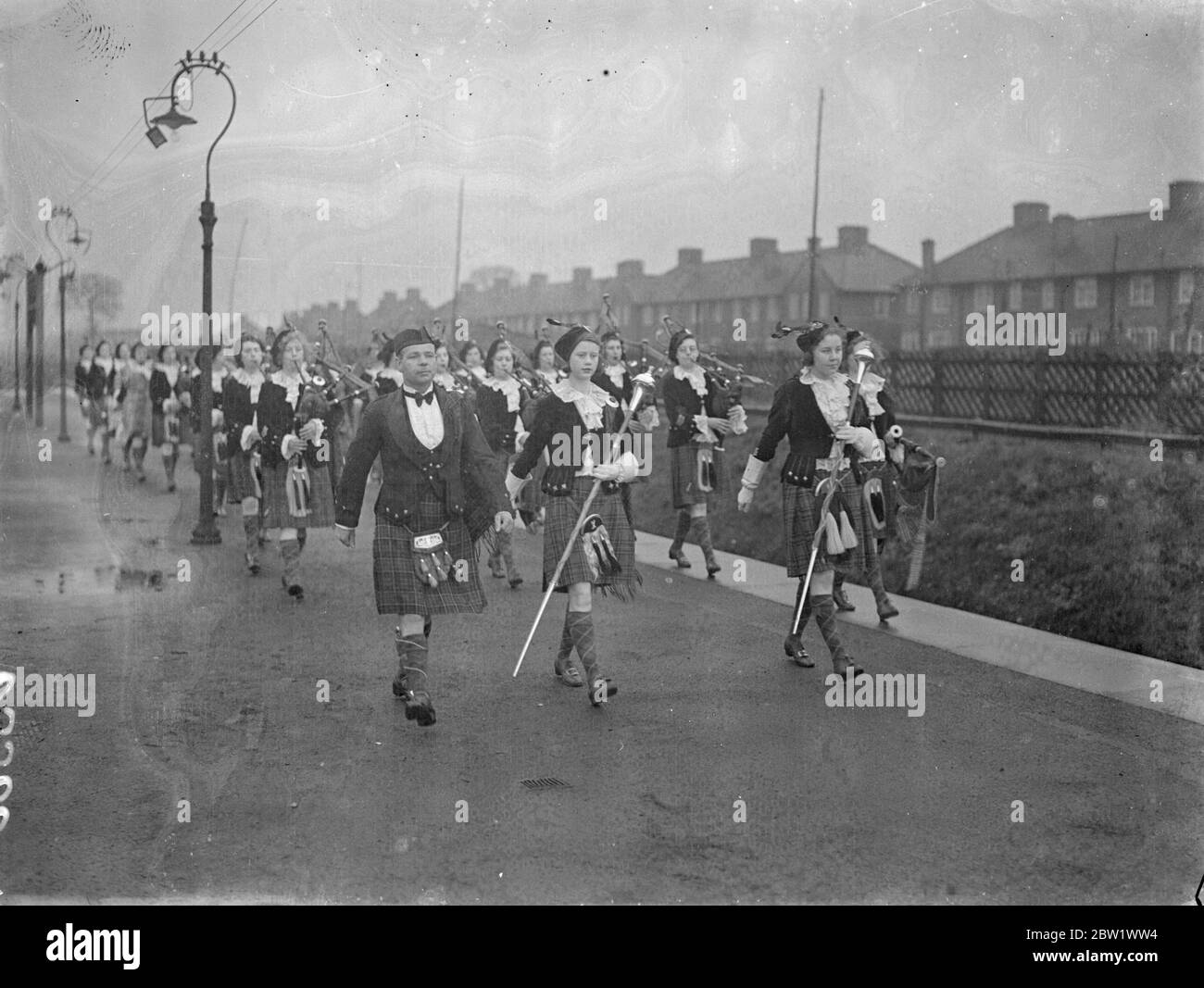 Dagenham Girl Pipers welcomed their new 'Chieftain'. Pipe Maj George Greenfield of the Royal Scots, recognised as one of Scotland's greatest experts on the bagpipes and Highland Dances, was met at Heathway station (District Railway) by the band of the Dagenham Girl Pipers in full uniform when he arrived at Dagenham, Essex, to become Pipe Maj of the Girl Pipers. George Greenfield enlisted in the Royal Scot as a boy piper and has now completed his 21 years service. As 'Chieftain' of the Dagenham Girl Pipers he will be responsible for the piping and dancing instruction of over 50 girls. Photo sho Stock Photo