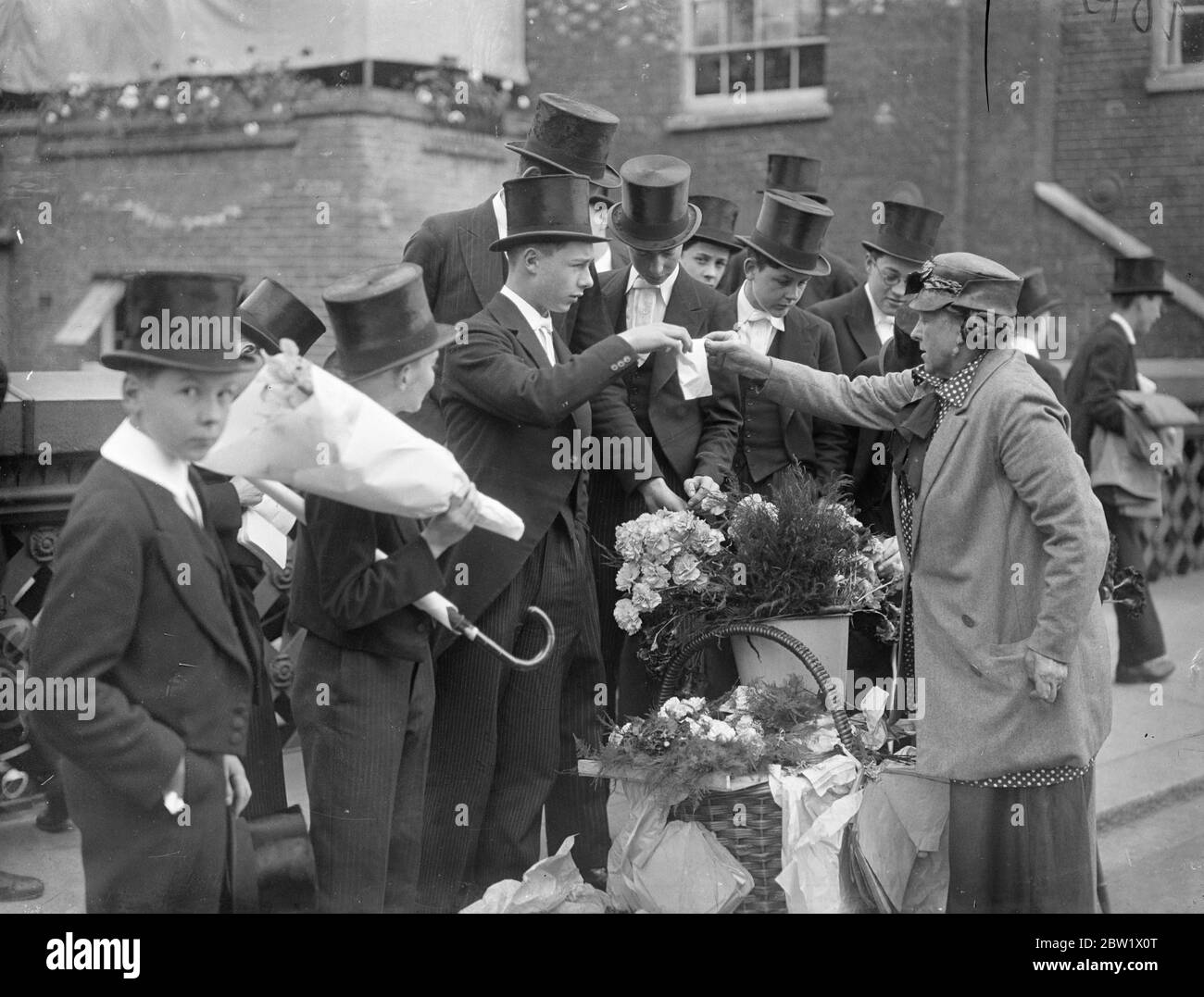 Eton boys buy fourth of June flowers. With a full programme of events, Eton College celebrated 4 June. The Coronation 'Fourth' was expected to be the most brilliant of any post-war year. Photo shows, Eton boys selecting their fourth of June flowers . 4 June 1937 Stock Photo