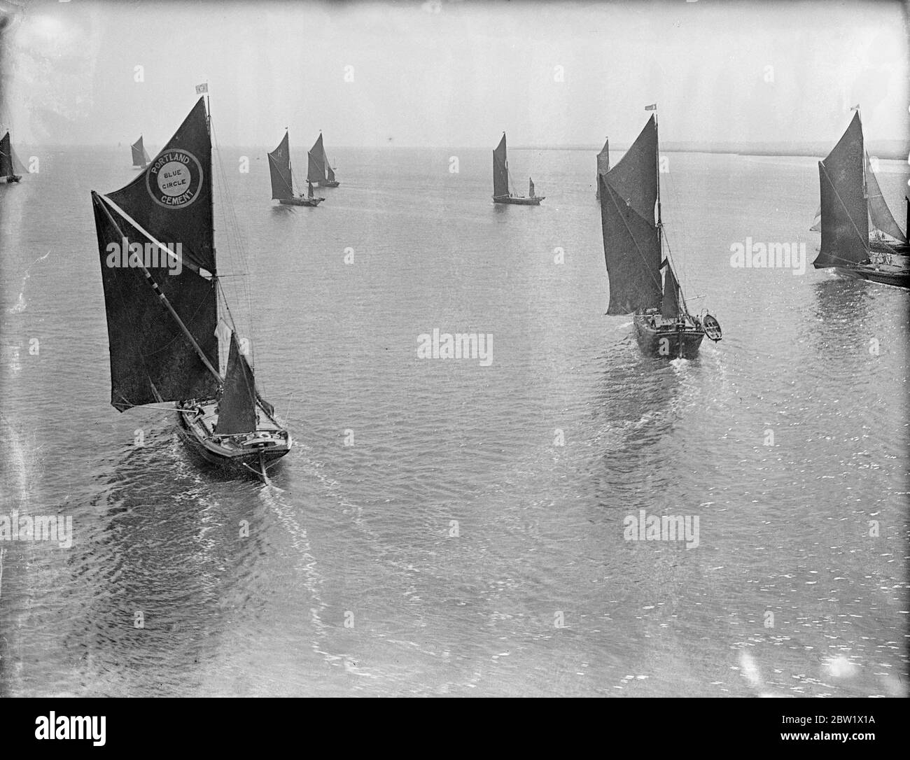 Picture from the air. Sailing barges in race on the Thames. 18 competitors, the largest number since the revival of the races 10 years ago, started from Lower Hope Point in the Coronation year sailing barge race on the Thames. The course was from Lower Hope Point to the Mouse Lightship and back to Gravesend, a distance of nearly 50 miles. Photo shows: the race in progress - air view. 3 June 1937 Stock Photo