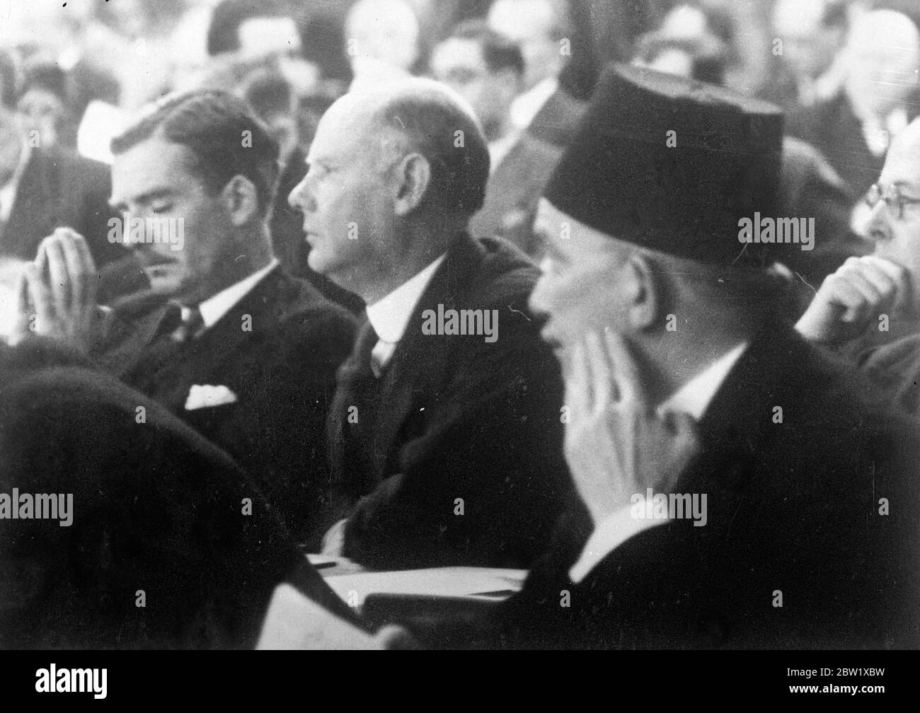 Prayful Mr Eden at the League meetings. Photo shows: Mr Anthony Eden (left), the British Foreign Minister, apparently in prayer as he somnolently listens to a speech at the League of Nations meeting in Geneva. His alert looking neighbour on right is a member of the Egyptian delegation which was attending the League's deliberations for the first time since Egypt's became completely independent under the Anglo-Egyptian Treaty. Britain sponsored Egypt's entry to the League. 27 May 1937 Stock Photo